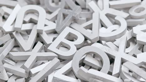 full frame close-up looped slowly rotating background of silver metal letters with selective focus