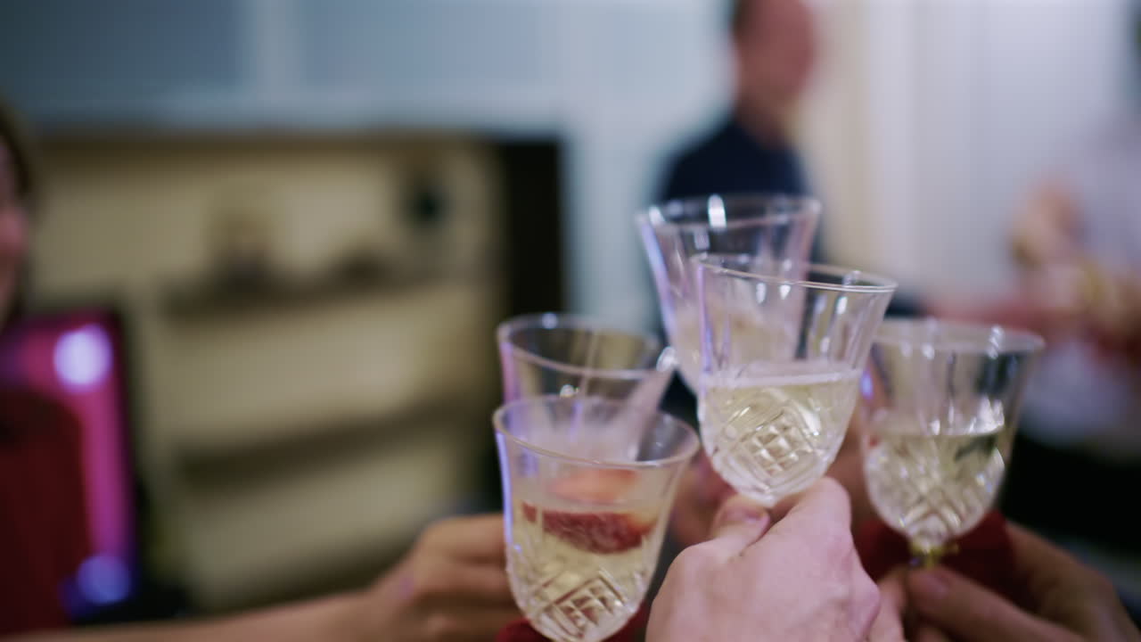Gruppe af mennesker, der skåler med champagneglas under en indendørs fejring.