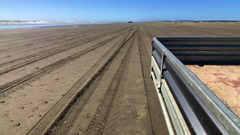 Ein-Faszinierender-Heckschuss-Aus-Einem-Fahrzeug,-Das-An-Einem-Neuseeländischen-Strand-Entlangfährt