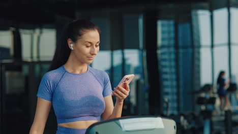 woman using phone on treadmill