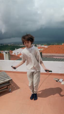 boy jumping rope on rooftop