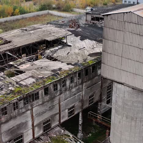 old abandoned factory. exterior of ruined buildings with many holes in the roof after military activity. damaged buildings outdoors. aerial view.