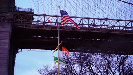 american flag under brooklyn bridge