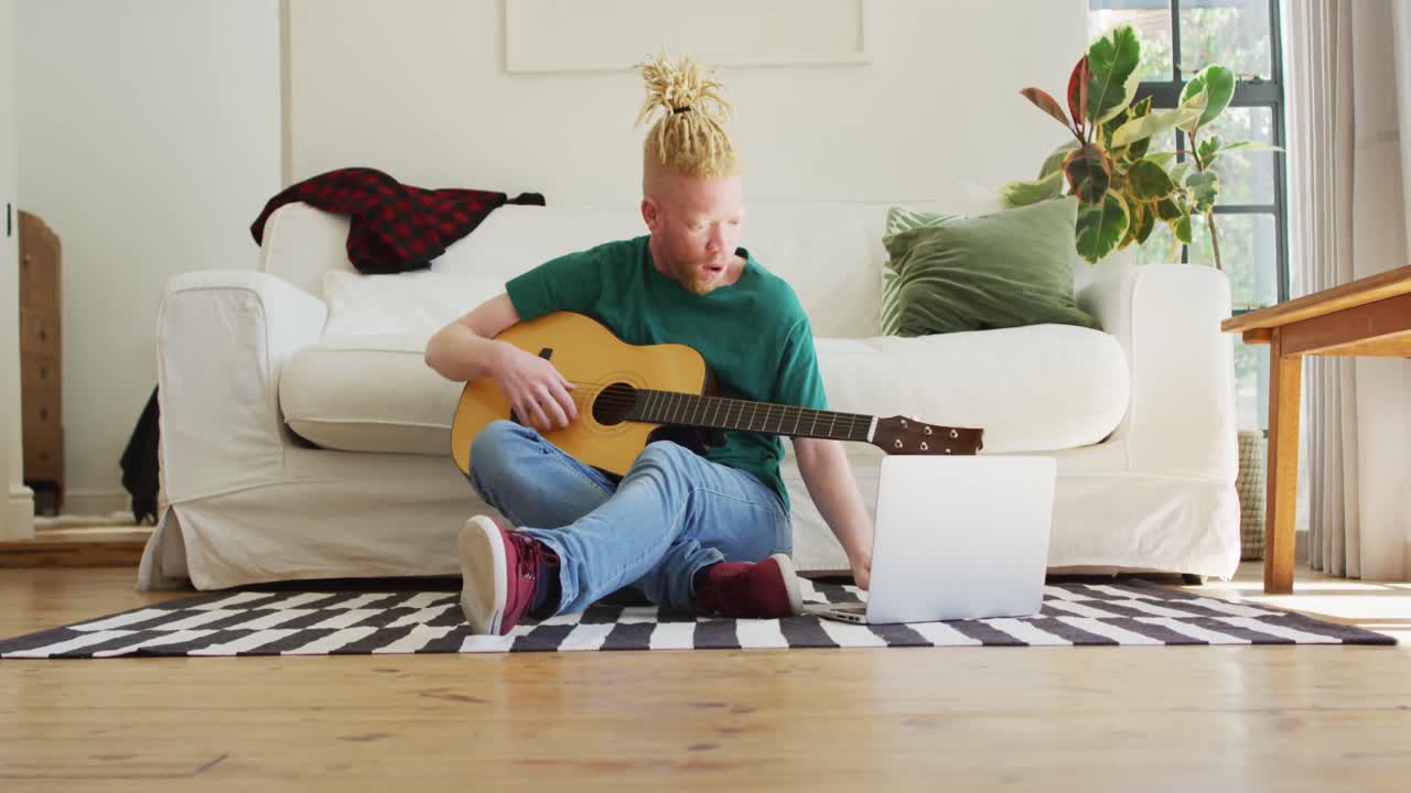 Albino african american man with dreadlocks playing guitars and singing