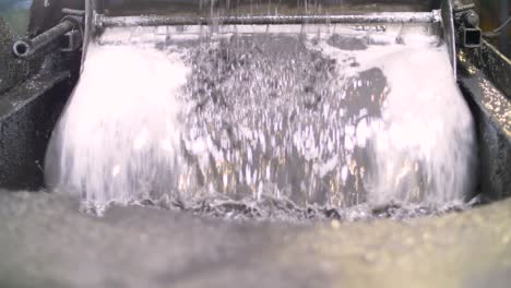 low angle of water vibrating to sift metal flakes in a recycling plant