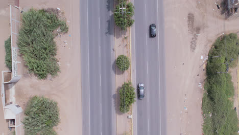 Beautiful-aerial-drone-shot-of-the-"Panamericana-Norte"-highway-in-northern-Peru-with-passing-cars-and-trucks