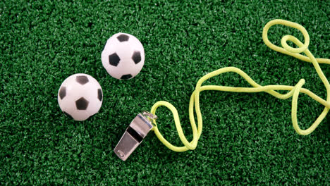 balones de fútbol y silbato del árbitro en césped artificial 4k