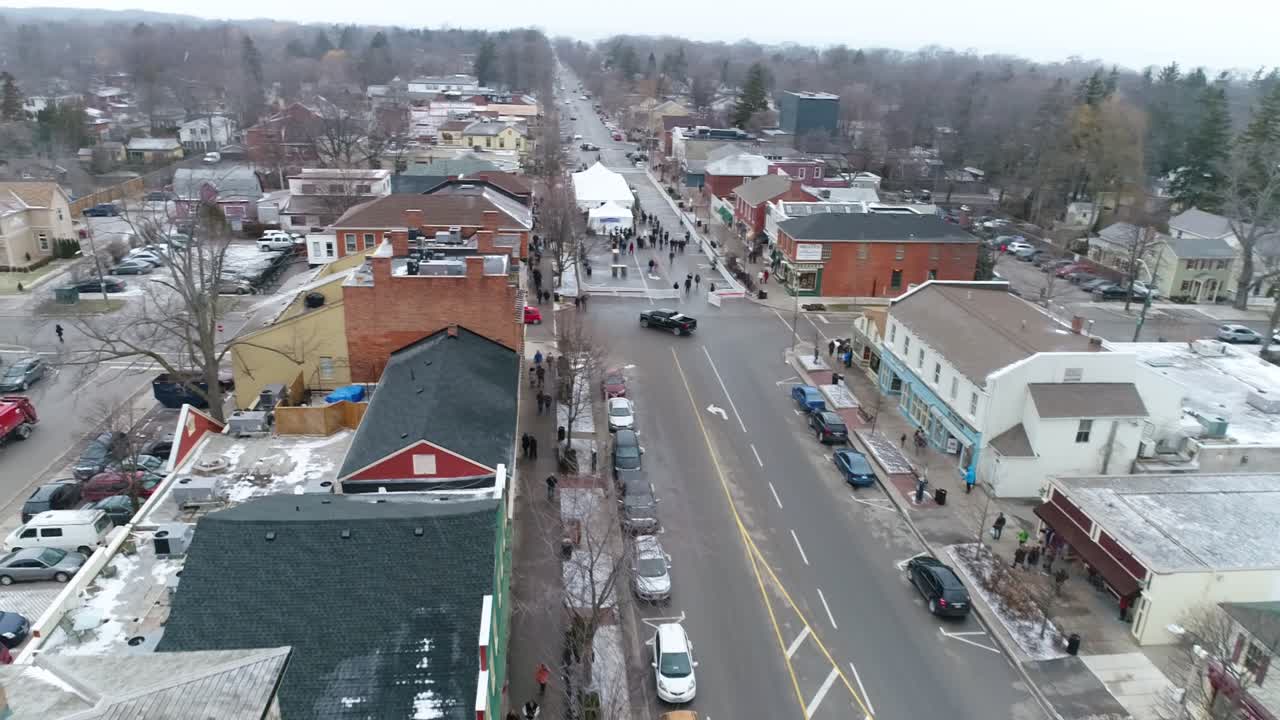 Dynamic flying aerial shot of Niagara-on-the-Lake's downtown courthouse, continuing down the main street that has historical buildings