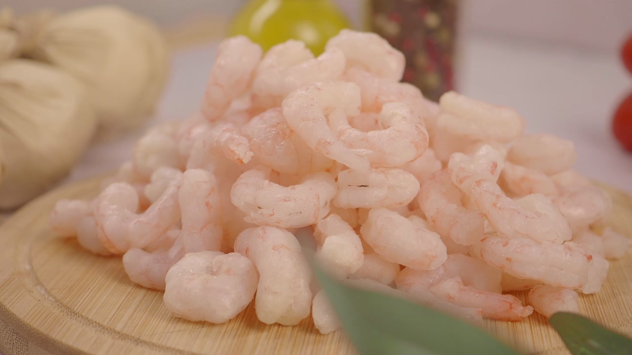 Pile of Cooked Peeled Shrimp on a Wooden Board
