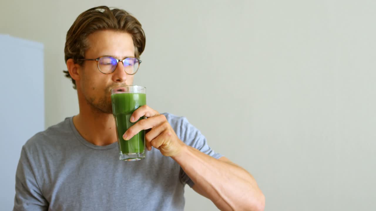 hombre tomando una bebida saludable en la cocina 4k