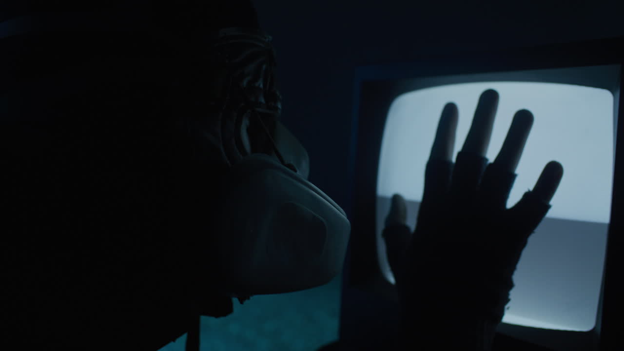 Person in Mask Looking at Retro TV Screen