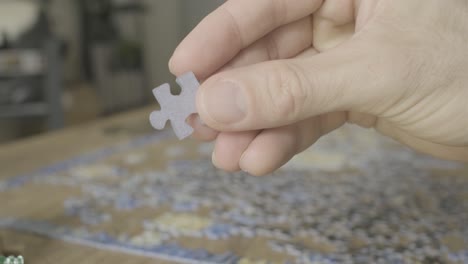 a guys hand holding a jigsaw puzzle piece