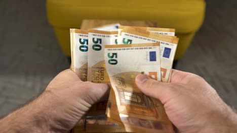 hands counting new fifty euro bills, money stack in background, close up