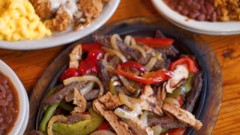 Tex-mex-fajita-platter-with-rice-and-beans,-overhead-slider-slow-motion-4K