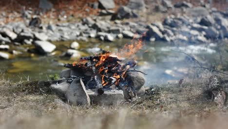 Burning-campfire-on-the-side-of-the-river