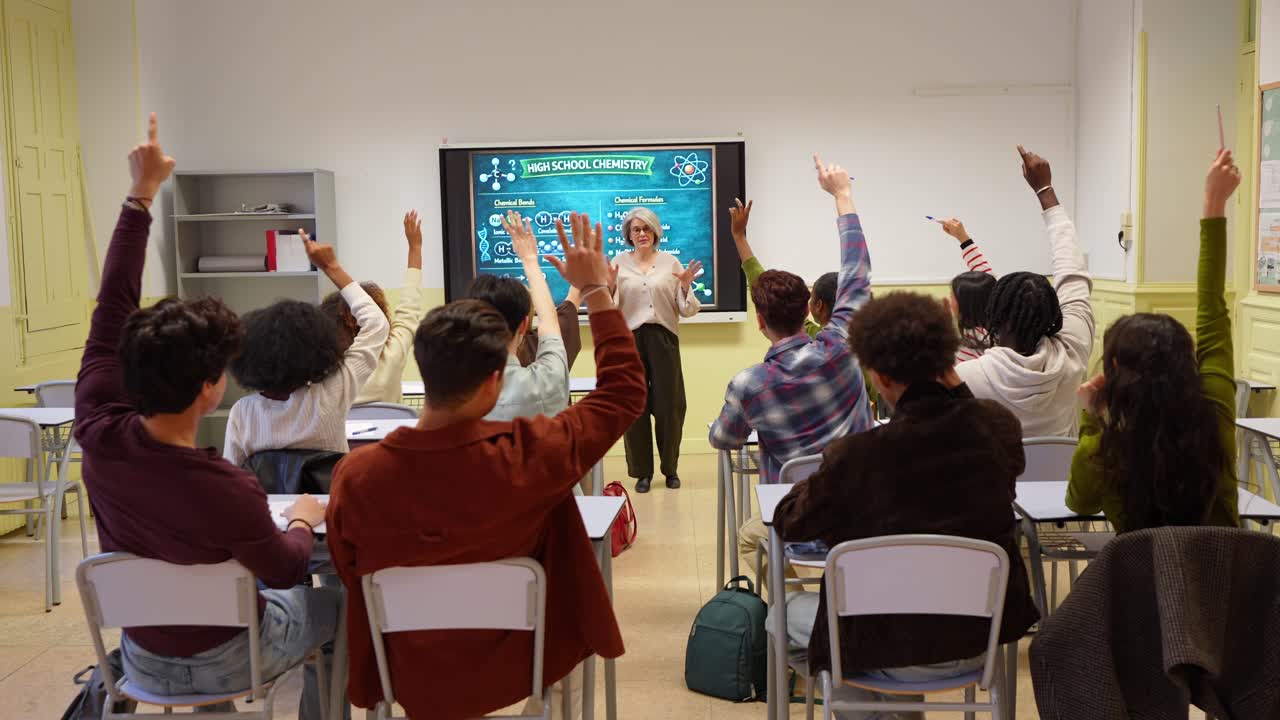 Teacher Lecturing to Diverse High School Students Raising Hands in Classroom