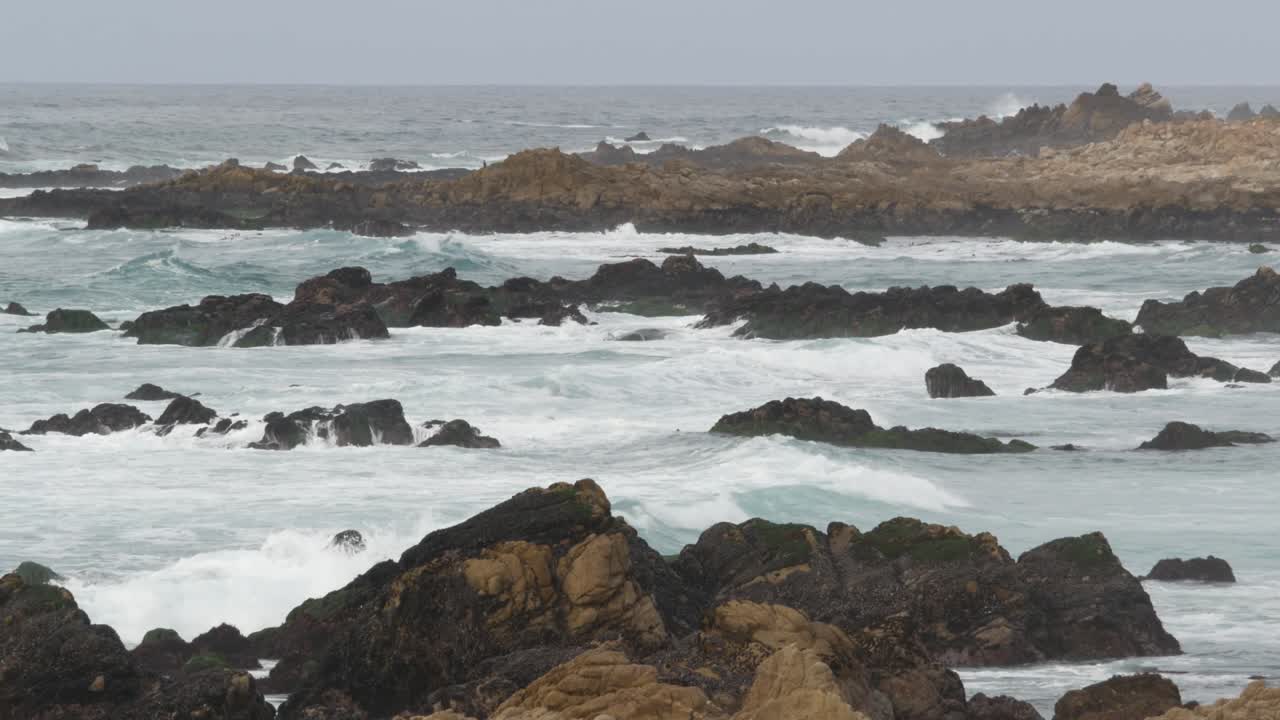 Costa oceanica rocciosa e frastagliata, onde del mare che si infrangono sulle rocce, Monterey California.