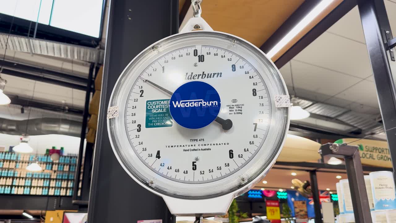 A hanging scale in a vibrant market setting with colorful produce and dynamic lighting