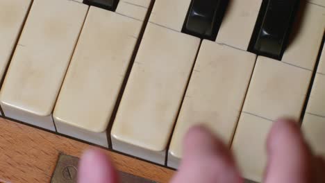 overhead shot of fingers playing a chord on a piano