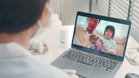 asian veterinarian girl talk to pet owner on online virtual video call. professional vet doctor woman use laptop computer to give treatment plan consult for little cat animal while sit in pet hospital