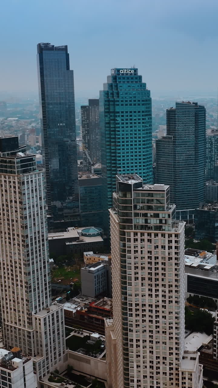 Multiple railways going beside the powerful skyscrapers. New York panorama from top view on grey day. Vertical video