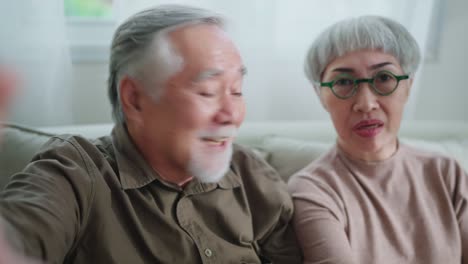 happiness heart warming old retired grand parent video calling conversation with their distance family together with careless and cheerful expression home interior background