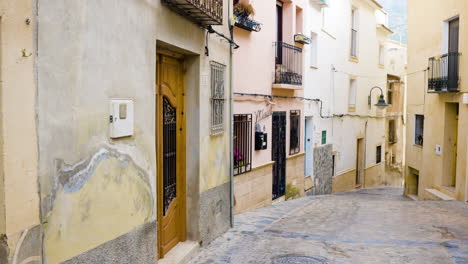 narrow spanish alleyway with pastel colored buildings
