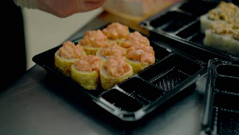 el cocinero prepara un rollo japonés pone la salsa sirve