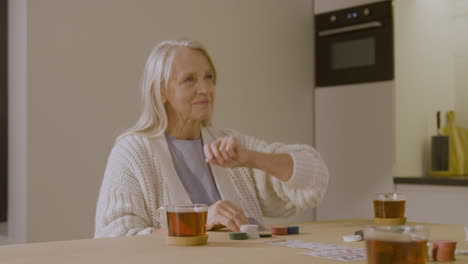 senior woman playing poker at home