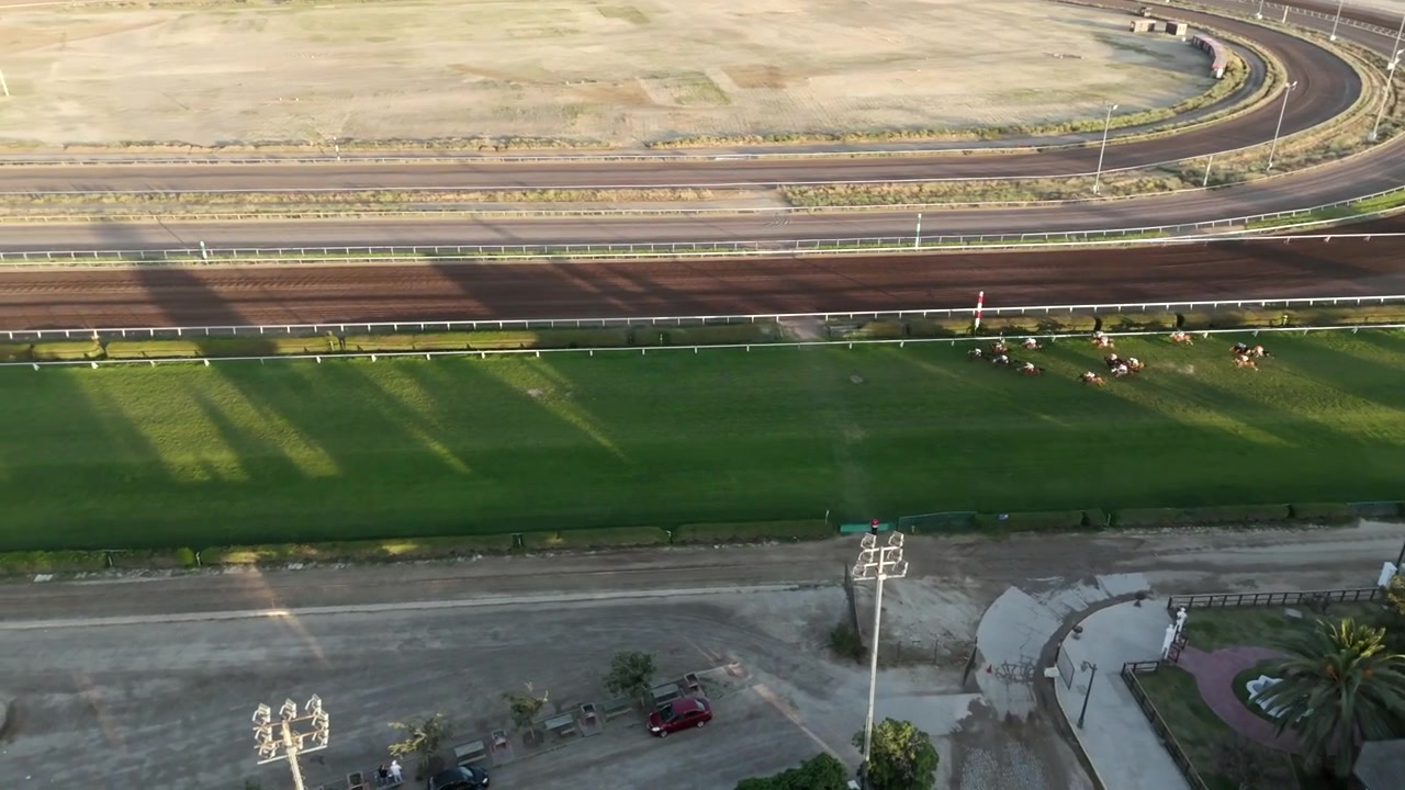 Panoramica aerea introduttiva sopra l'ippodromo Club Hípico de Santiago con una vegetazione rigogliosa, Santiago, Cile, mentre i concorrenti si allenano