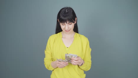 Woman-counting-money-looking-at-camera.