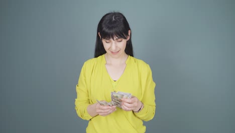 카메라를 쳐다보며 돈을 세는 여자.