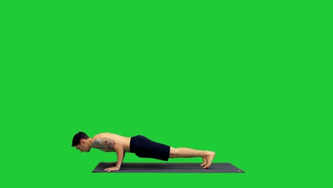 young man doing yoga on a green screen, chroma key