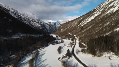 scenic view of a road by towering winter mountains - trollstigen road in norway