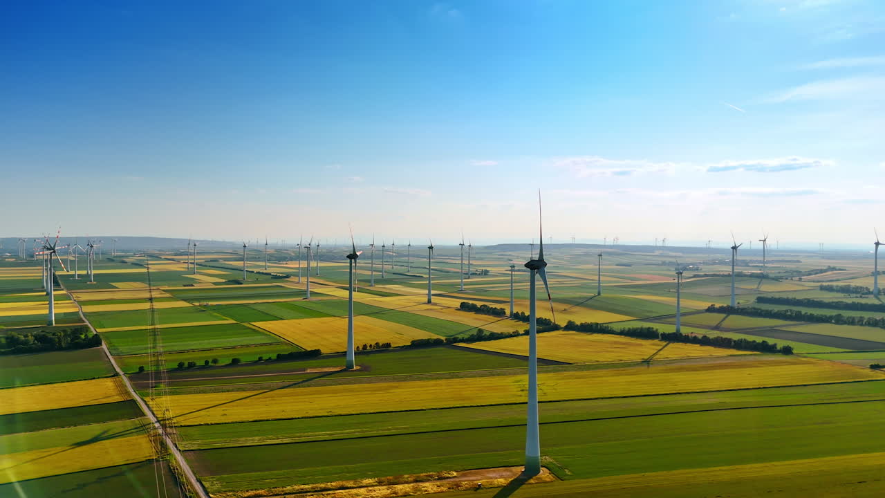 Windmills rotate slowly in the wind. Spectacular countryside with wind farms producing clean energy.
