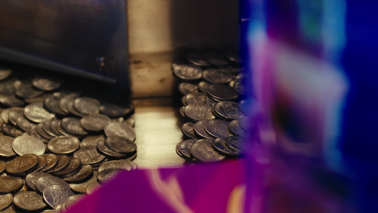 una pila de monedas de cuarto dentro de la máquina de juegos de azar en el parque de atracciones
