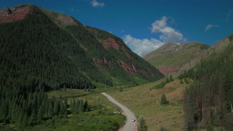 Antena-Dron-Cinemática-Hielo-Lago-Cuenca-Inicio-Del-Sendero-Conduciendo-Furgoneta-Carretera-Del-Condado-Por-Río-Verano-Temprano-En-La-Mañana-Silverton-Telluride-Colorado-Montañas-Rocosas-álamo-Temblón-Bosque-De-Pinos-14er-Picos-Adelante-Seguir-Movimiento