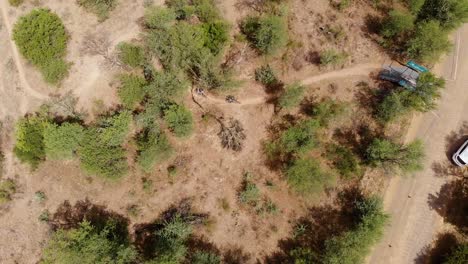 Drone-Fly-Over-Following-Three-Mountain-Bikers-into-Establishment-on-a-Warm-Sunny-Day