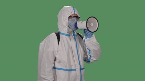 portrait of a man in a protective suit, safety glasses, gloves and mask speaks into a megaphone warning people about danger, waves come here. green screen, chroma key. slow motion. close up