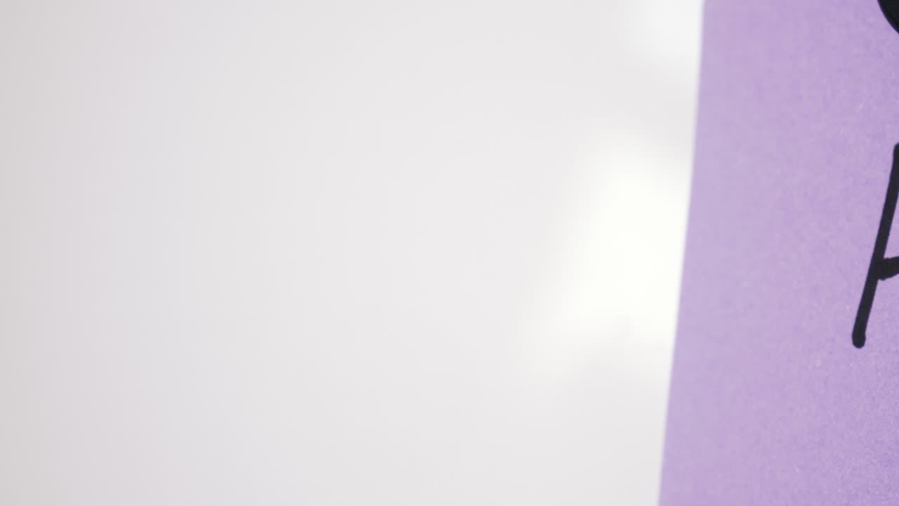 Pan reveal of AI text on purple note held by magnet on whiteboard with selective focus