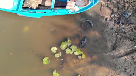 Aerial-drone-bird's-eye-view-flight-over-boats-and-green-river-side