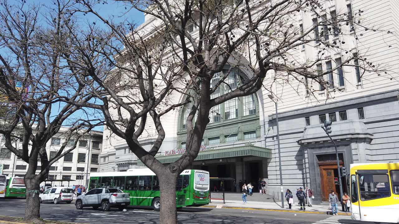 Side view of Constitución Railway station with street traffic, cars and buses driving by, panoramic at daylight