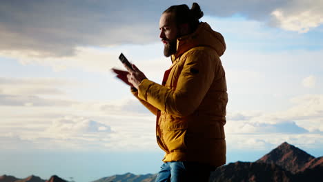 careless hiker tries to make a phone call on the mountain top and falling off