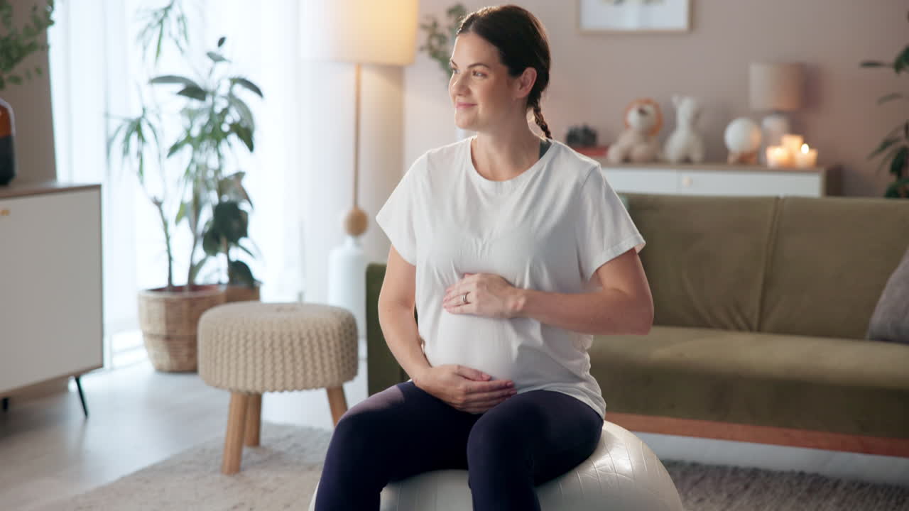 Pregnant woman relaxing at home on exercise ball