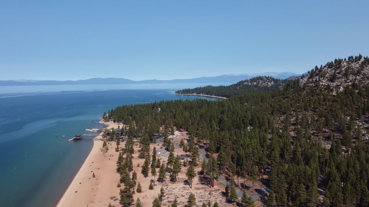 Counterclockwise drone shot of Nevada Beach, the surrounding forest, and Lake Tahoe on a beautiful day in Nevada