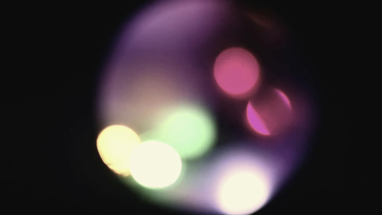 Luci bokeh colorate che si spostano su sfondo scuro