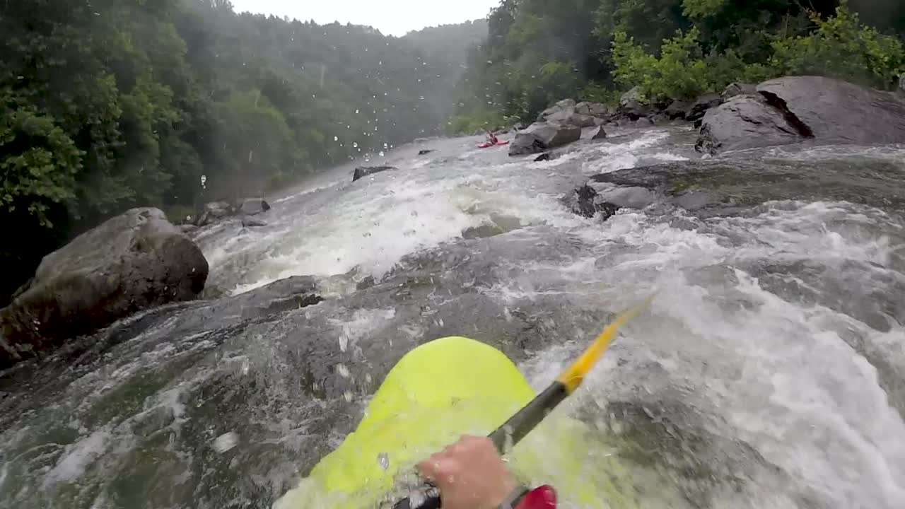 POV di Kayak in acque bianche attraverso un fiume roccioso