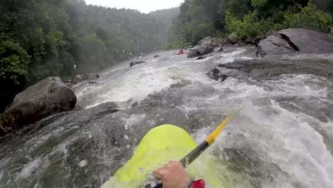 pov of white water kayaking through rocky river