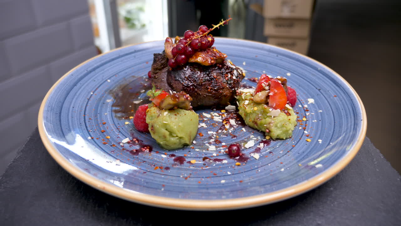 Gourmet Steak Dish with Red Currants and Mashed Avocado