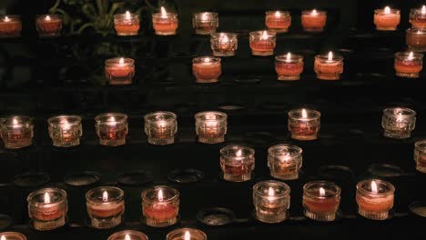 Filas-De-Velas-De-Oración-Rojas-En-Una-Iglesia